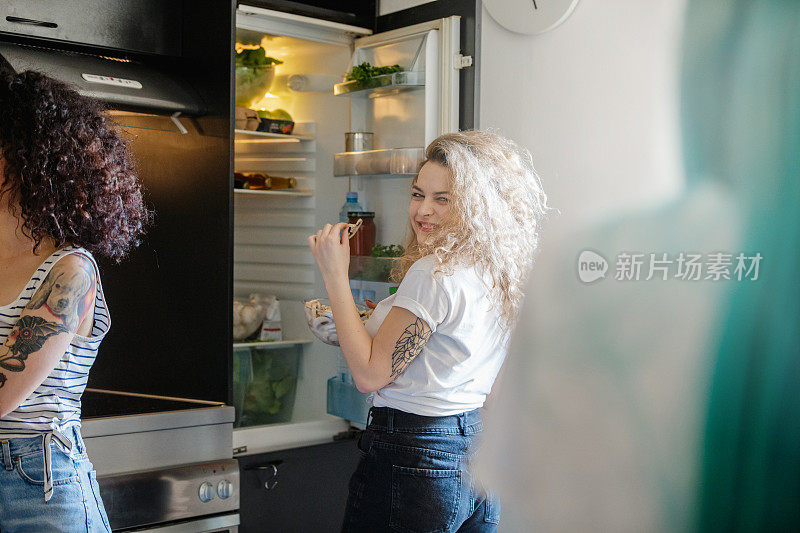金发年轻女人，冰箱边放着一碗蘑菇