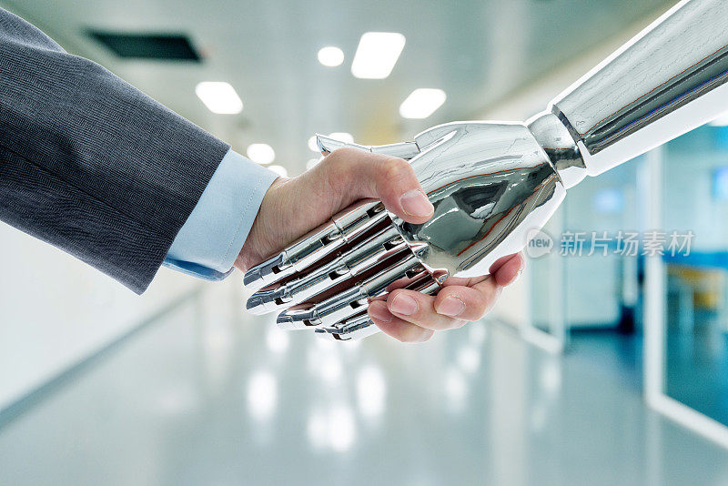 商人和机器人握手在现代办公室的背景