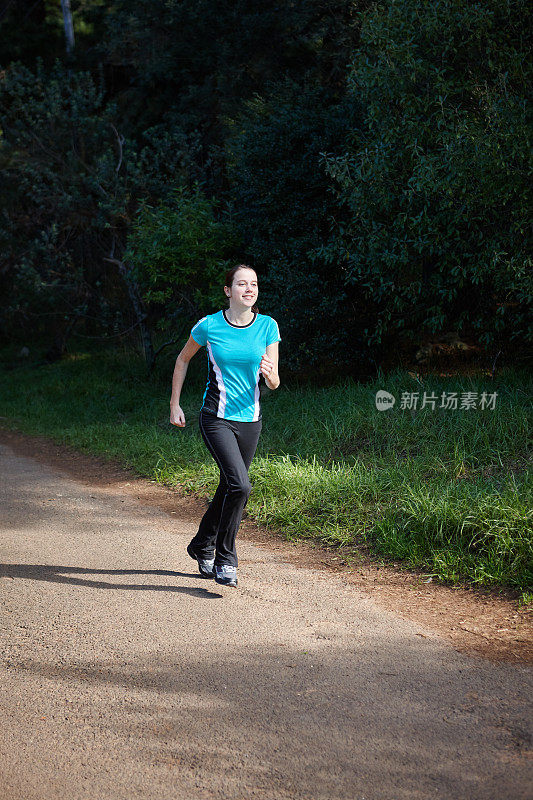 美丽的年轻女子在森林里奔跑以保持健康