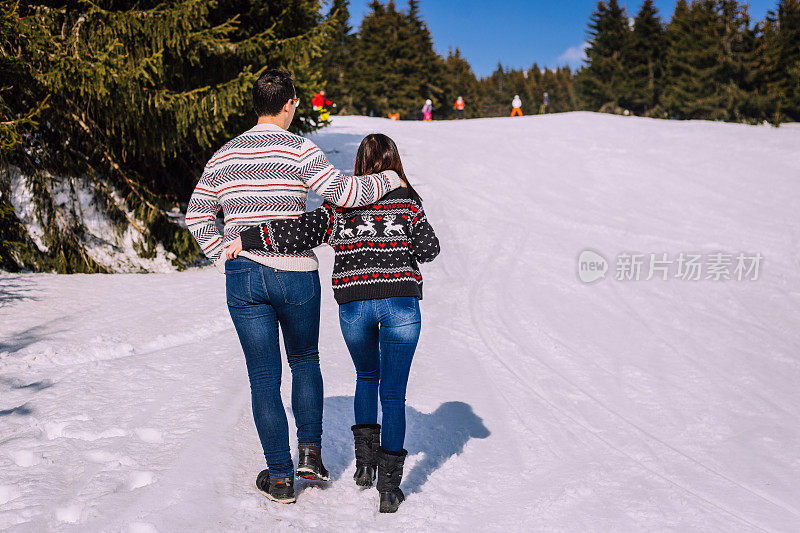 一对在雪地上散步的夫妇