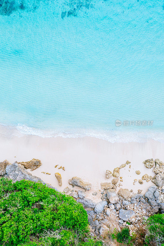 蓝色的海洋，白色的沙滩和覆盖着热带植物的悬崖。从上面俯瞰巴厘岛海岸。无人机拍摄。