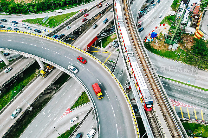 无人机拍摄繁忙的交通十字路口和城市铁路桥上的通勤火车