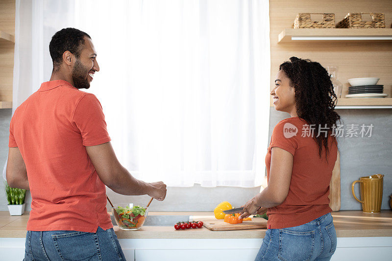快乐的年轻非裔美国男人和女人一起准备沙拉有机蔬菜