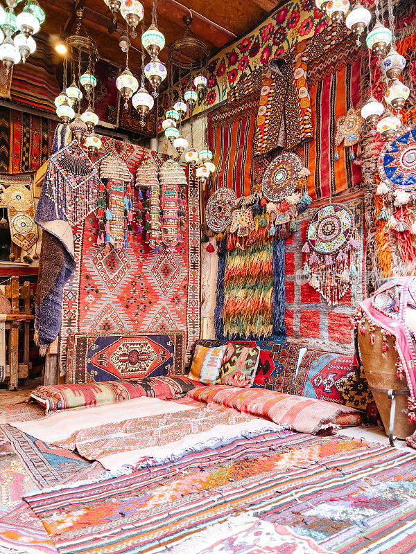 令人惊叹的传统手工土耳其地毯在巴扎市场。彩色织物的马赛克。晚上点燃，创造一个舒适的氛围