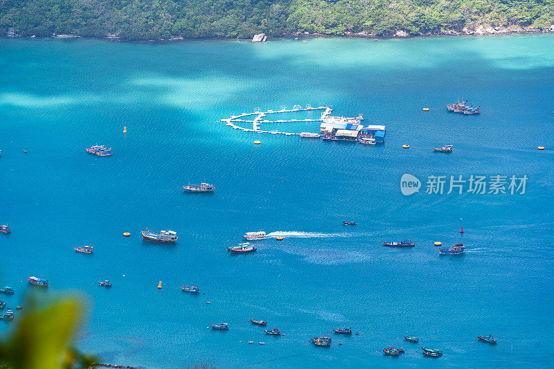 越南孔岛本丹港，湛蓝的大海，蓝天山和五颜六色的船只。