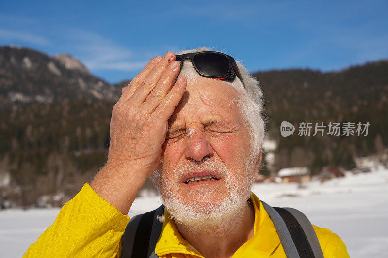 老人的肖像，帕金森病患者用雪冷却他的脸，闭上眼睛紧张，在斯洛文尼亚越野滑雪