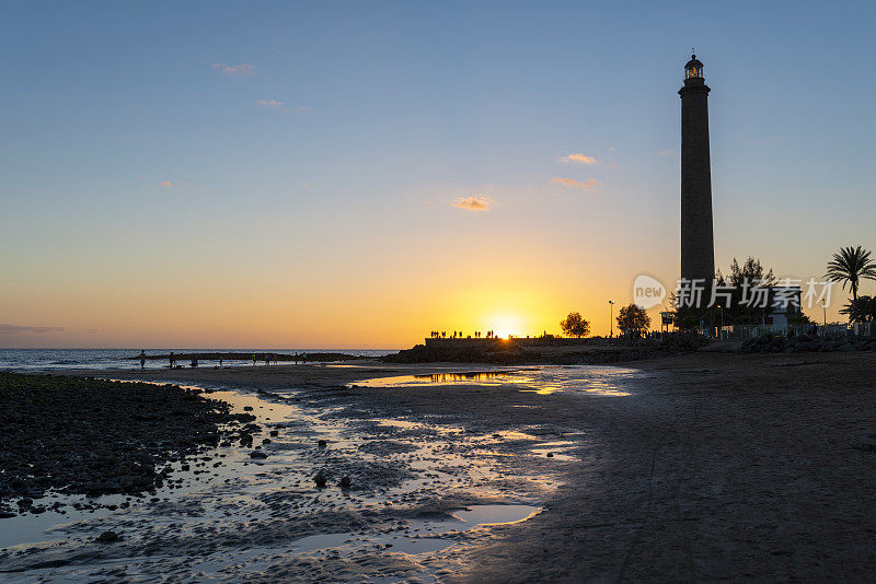 在大加那利岛马斯帕洛马斯市的海滩上，美丽的日落景色和灯塔。