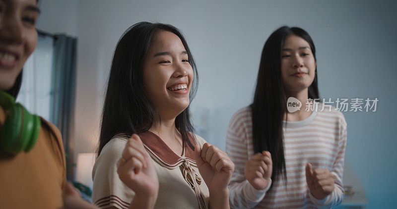 一群年轻女子喜欢在家通过智能手机练习跳舞