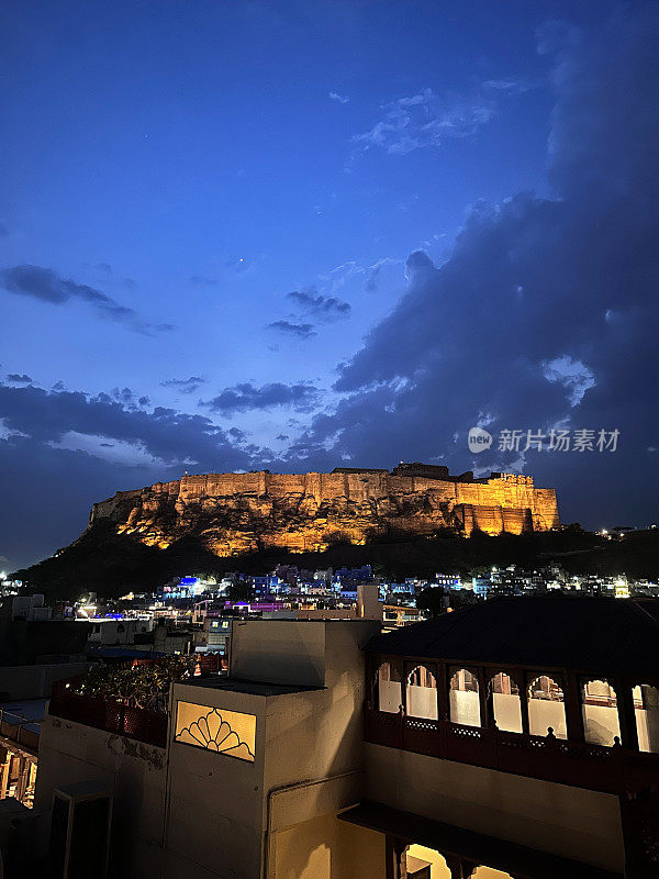 印度拉贾斯坦邦焦特布尔老城区和Mehrangarh堡的屋顶视图，蓝色城市的建筑物和建筑，照亮的黄昏视图，聚焦于前景