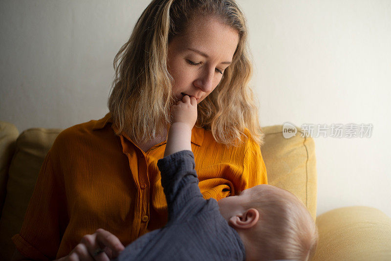 妇女，婴儿和母乳喂养在家里的沙发上与爱，连接和营养健康成长。母亲，哺乳和婴儿的食物，牛奶或健康与亲密的沙发在家里的房子