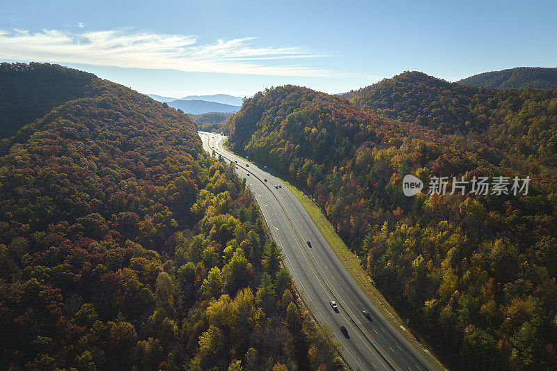 从北卡罗莱纳州的I-40高速公路上俯瞰，通往阿什维尔，穿过阿巴拉契亚山脉，黄色的秋天树林和快速移动的卡车和汽车。州际运输概念