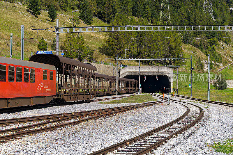 汽车穿梭列车停在火车站在瑞士阿尔卑斯山的村庄的缩小视角。