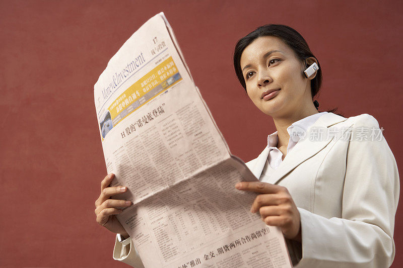 年轻商务女性在看报纸