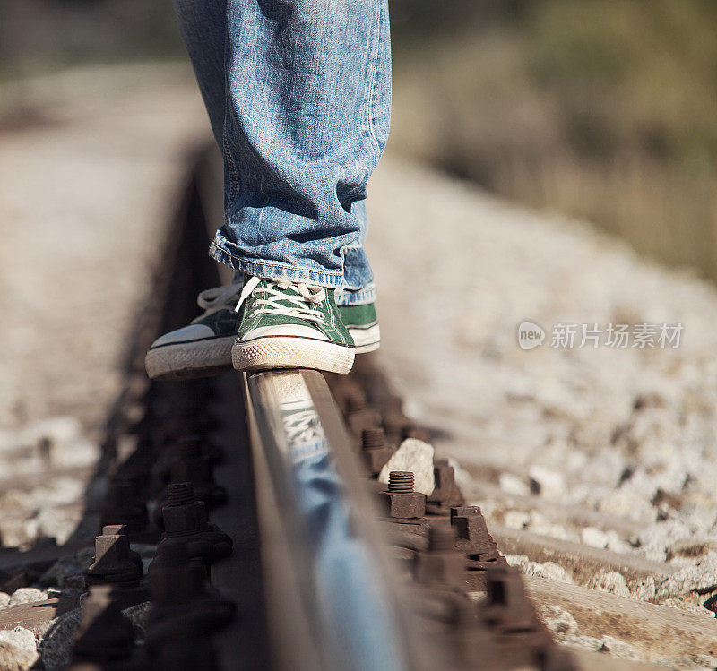 近距离拍摄在铁路上的运动鞋腿