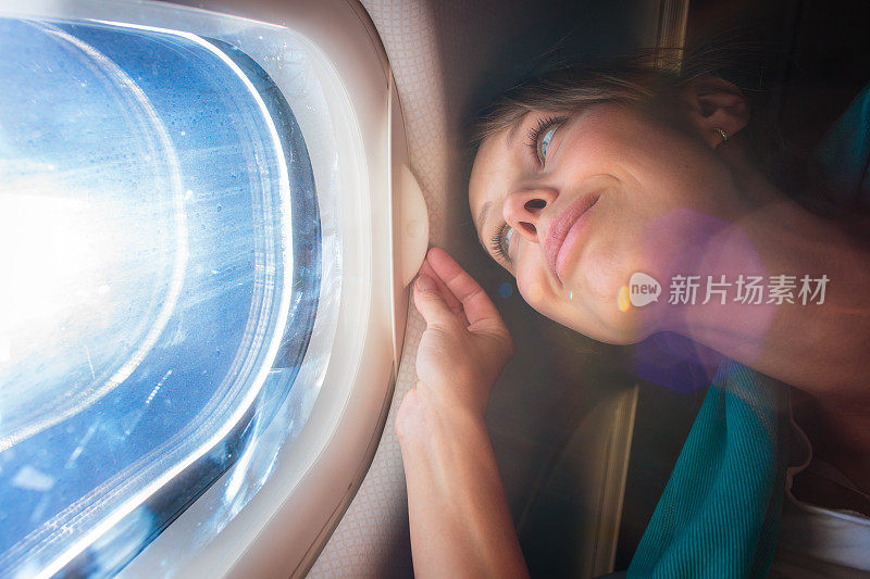 女飞机乘客正在欣赏窗外的景色