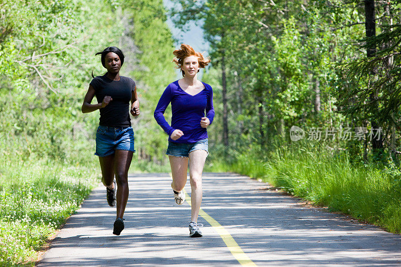 两个女人在树林里的小路上奔跑