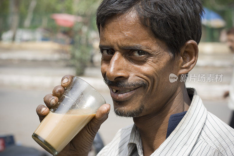 快乐的印度人力车车夫正在喝着茶