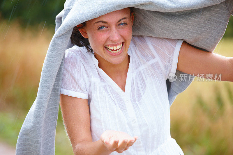 快乐的年轻女子享受着雨