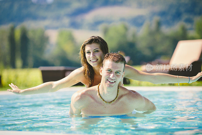 年轻夫妇在游泳池里