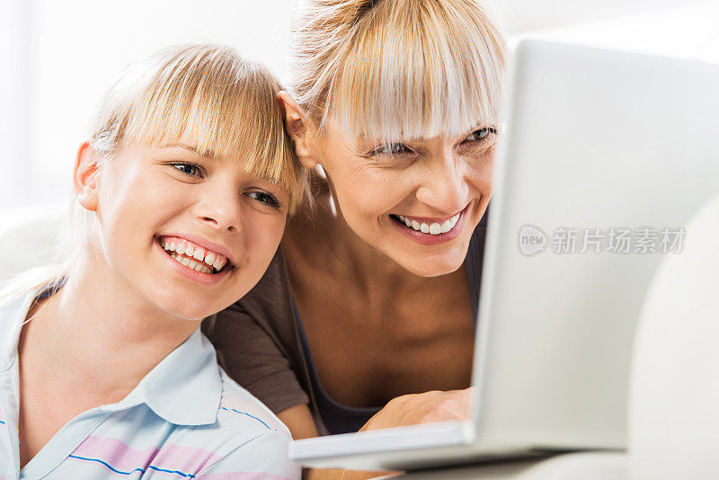母女俩在用笔记本电脑。