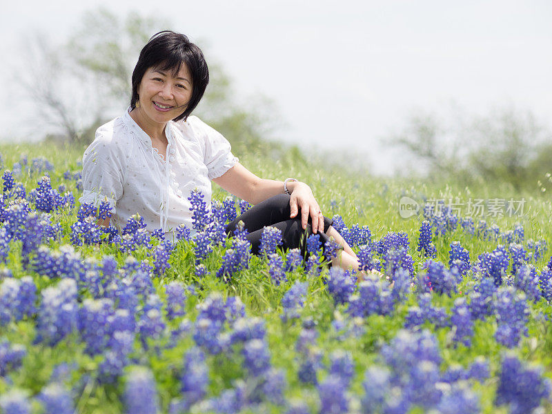 一个亚洲女人在德州矢车菊地里