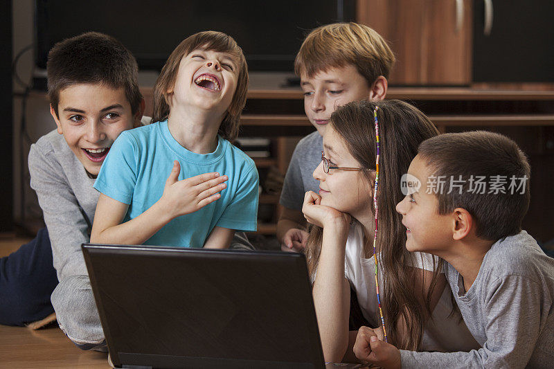 可爱的孩子们笑着玩笔记本电脑