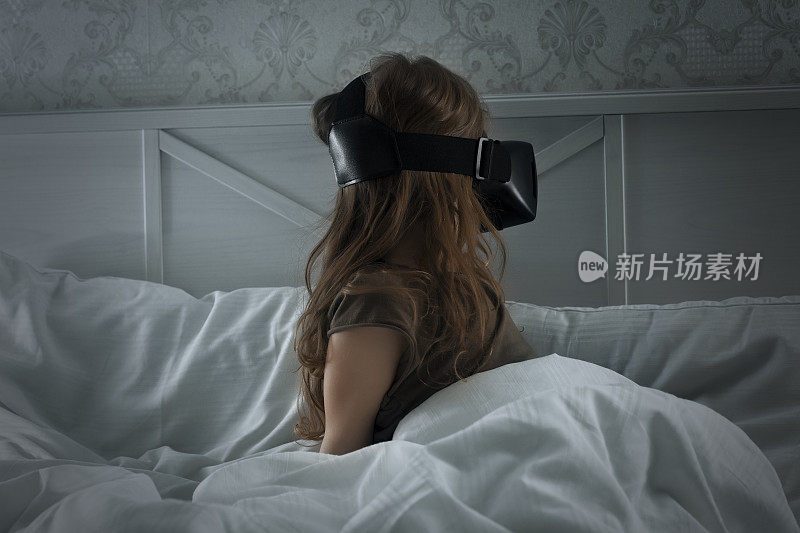 小女孩戴着VR眼镜玩网络