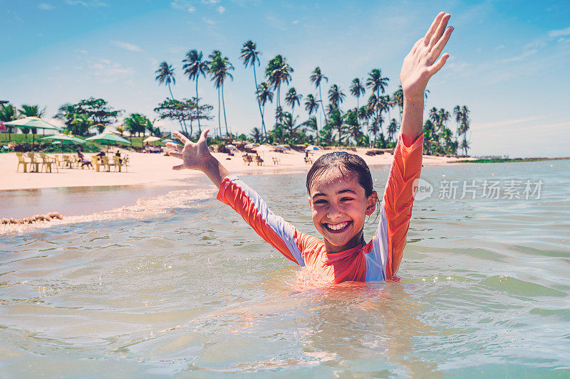 快乐的少女享受巴西夏天在热带海溅水