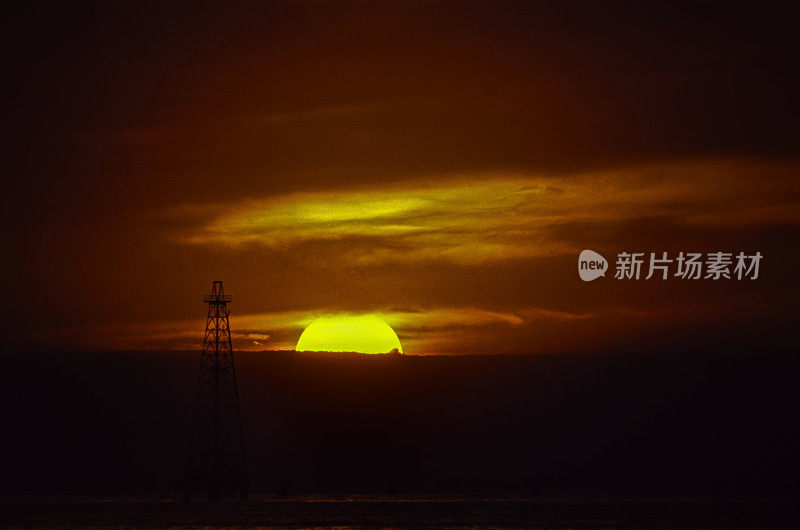 夕阳下海面上的石油钻塔