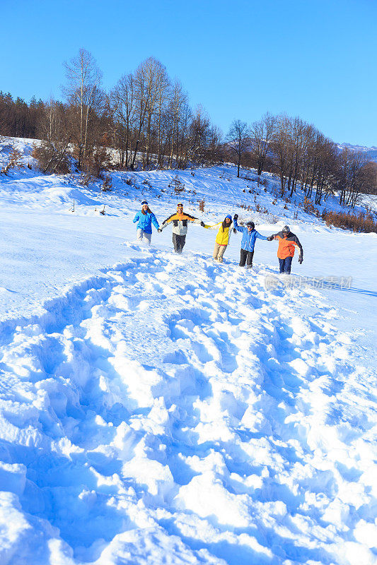 一群年轻人在跑步，享受雪