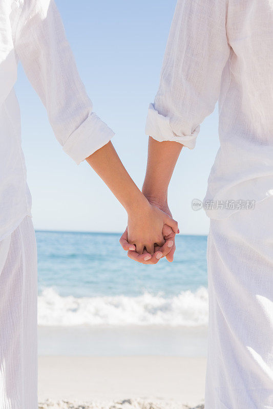 一对在海边牵着手的夫妇