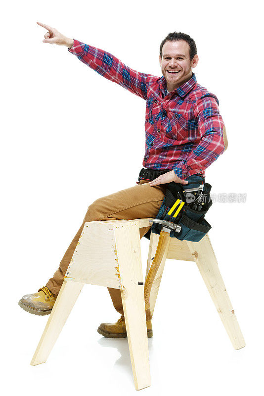 快乐的木匠坐在锯木架上指着