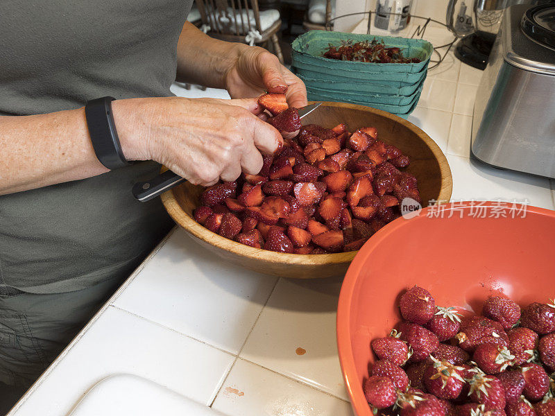 碗里的新鲜草莓被去茎切片放在厨房柜台上