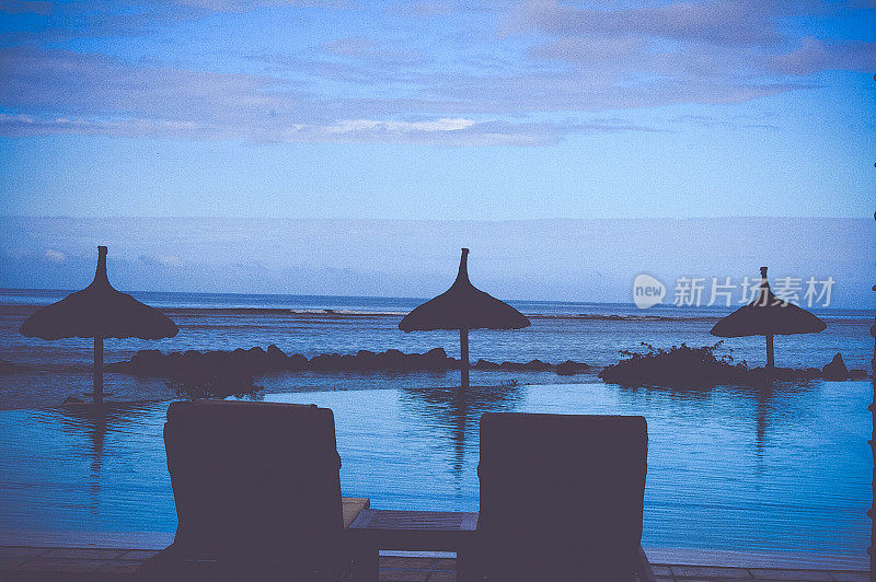 热带岛屿和无限游泳池在蓝色的背景