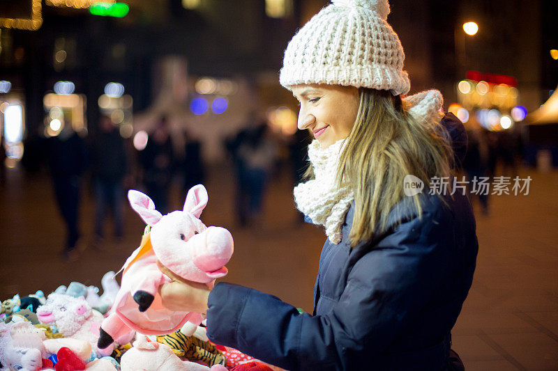 年轻女子在街上看玩具
