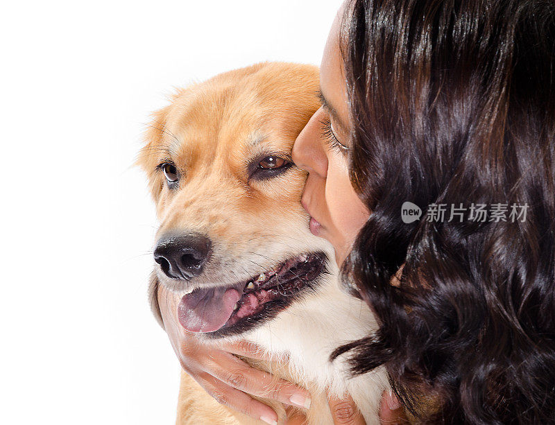 年轻女子亲吻金毛猎犬混合狗