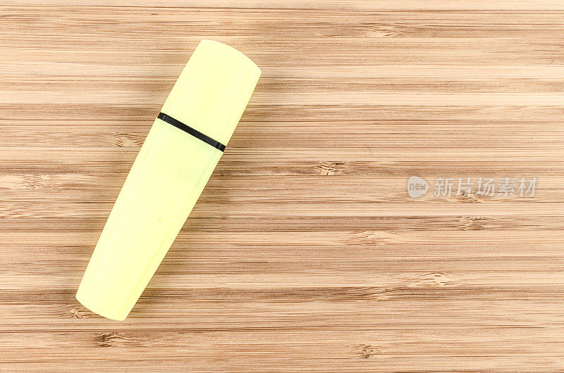 木制桌子上的黄色荧光笔