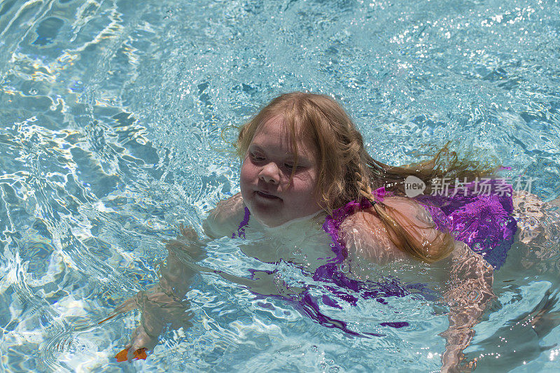 患有唐氏综合症的女孩在游泳池游泳
