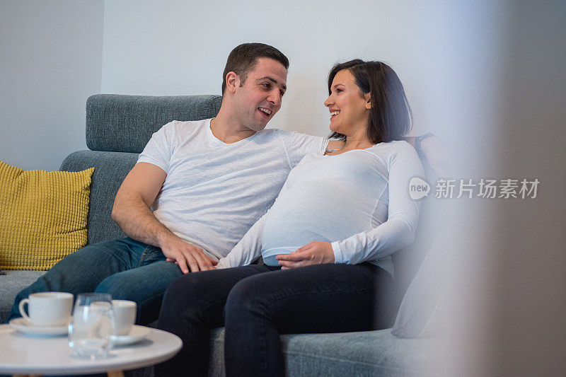 一个男人在和他怀孕的妻子说话