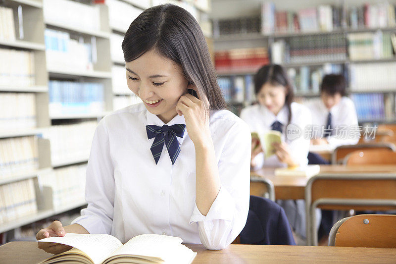 女高中生在图书馆打开书
