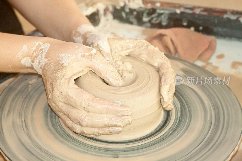 女性的手在陶轮上工作