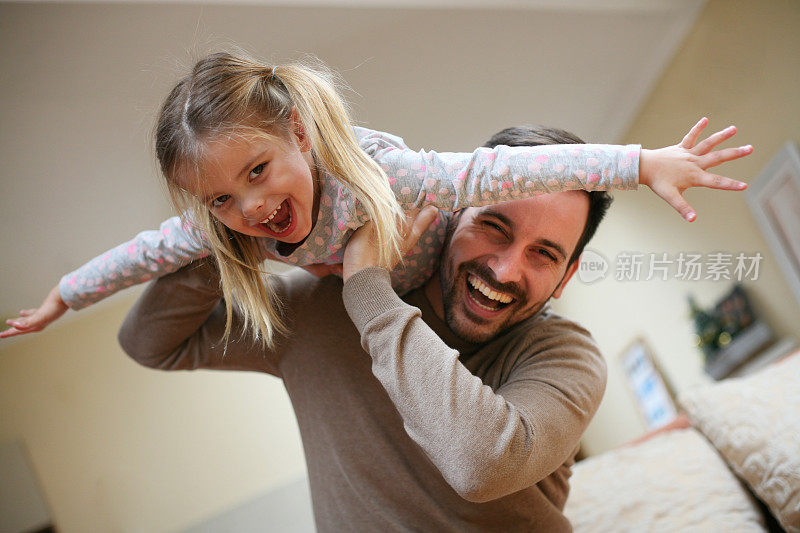 年轻的爸爸和可爱的女儿在家。