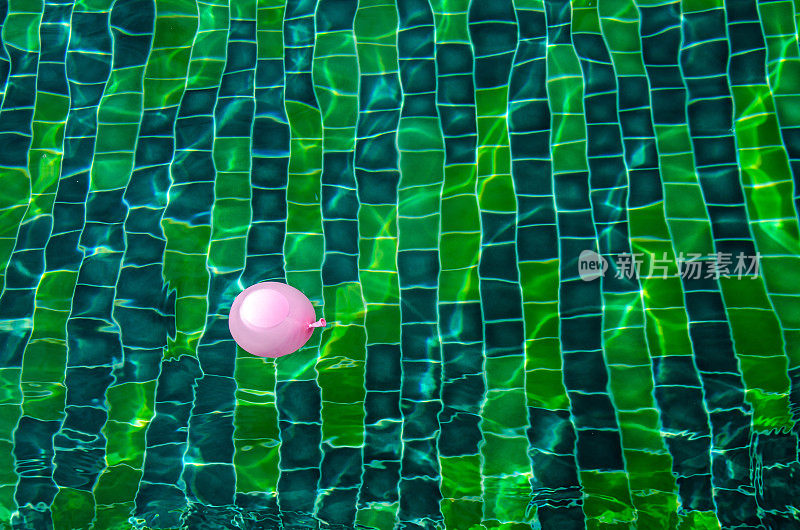 绿色游泳池的表面，游泳池的水的背景。游泳池里有气球。