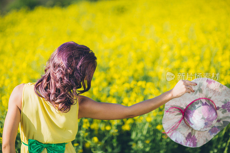 女孩在油菜籽草地上玩