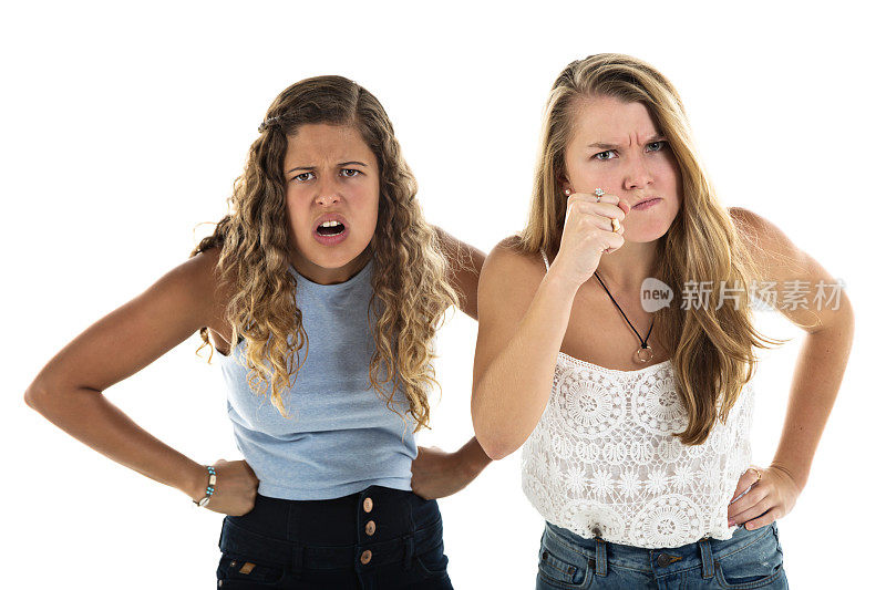 两个愤怒的女孩做着鬼脸，一个挥舞着拳头，一个大喊大叫