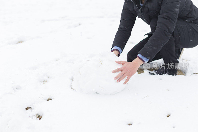 一个年轻的亚洲人在雪地里玩