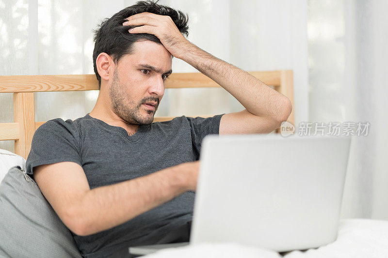悲惨的失业男性在查看一封显示他紧张的电子邮件后担心。