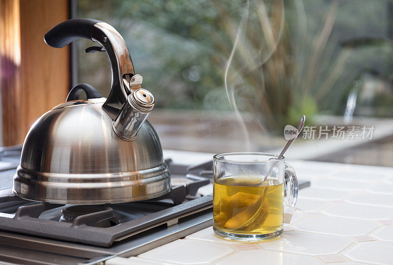 有蒸汽的茶壶和一杯茶