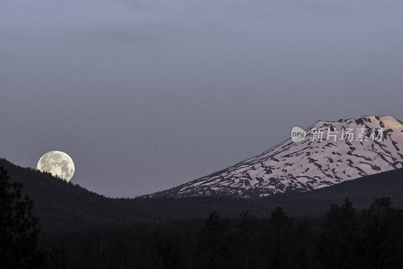 在美国俄勒冈州中部的喀斯喀特山脉，满月正落在学士山上