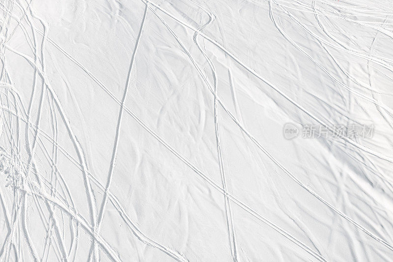 在有标记的滑雪坡道外，滑雪者在深雪上留下的足迹